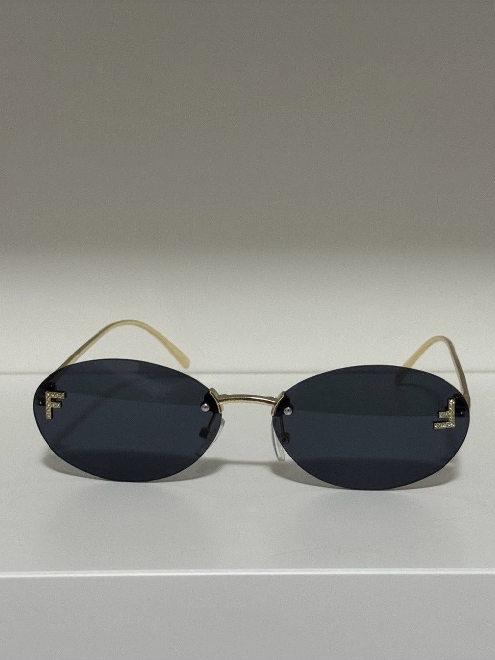 Designer Rimless Oval Sunglasses in Black with Gold Temples